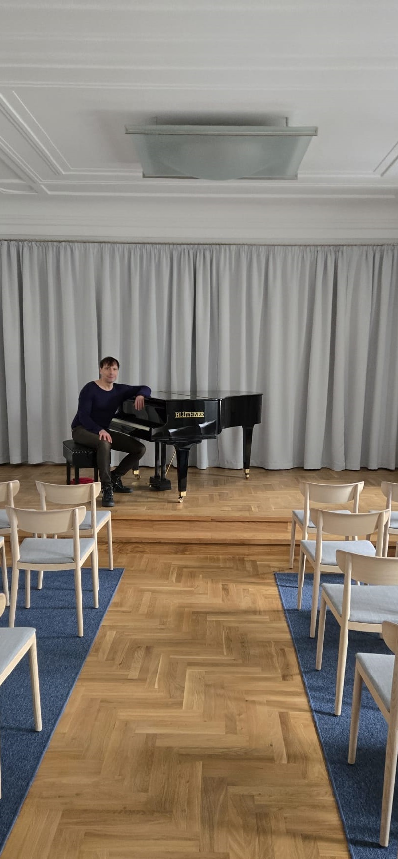 Karsten sitzt an einem schwarzen Flügel